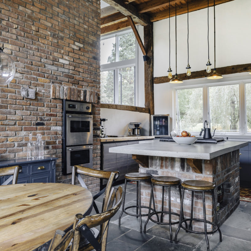 Rustic-styled, sun-drenched kitchen connected to a large dining area.